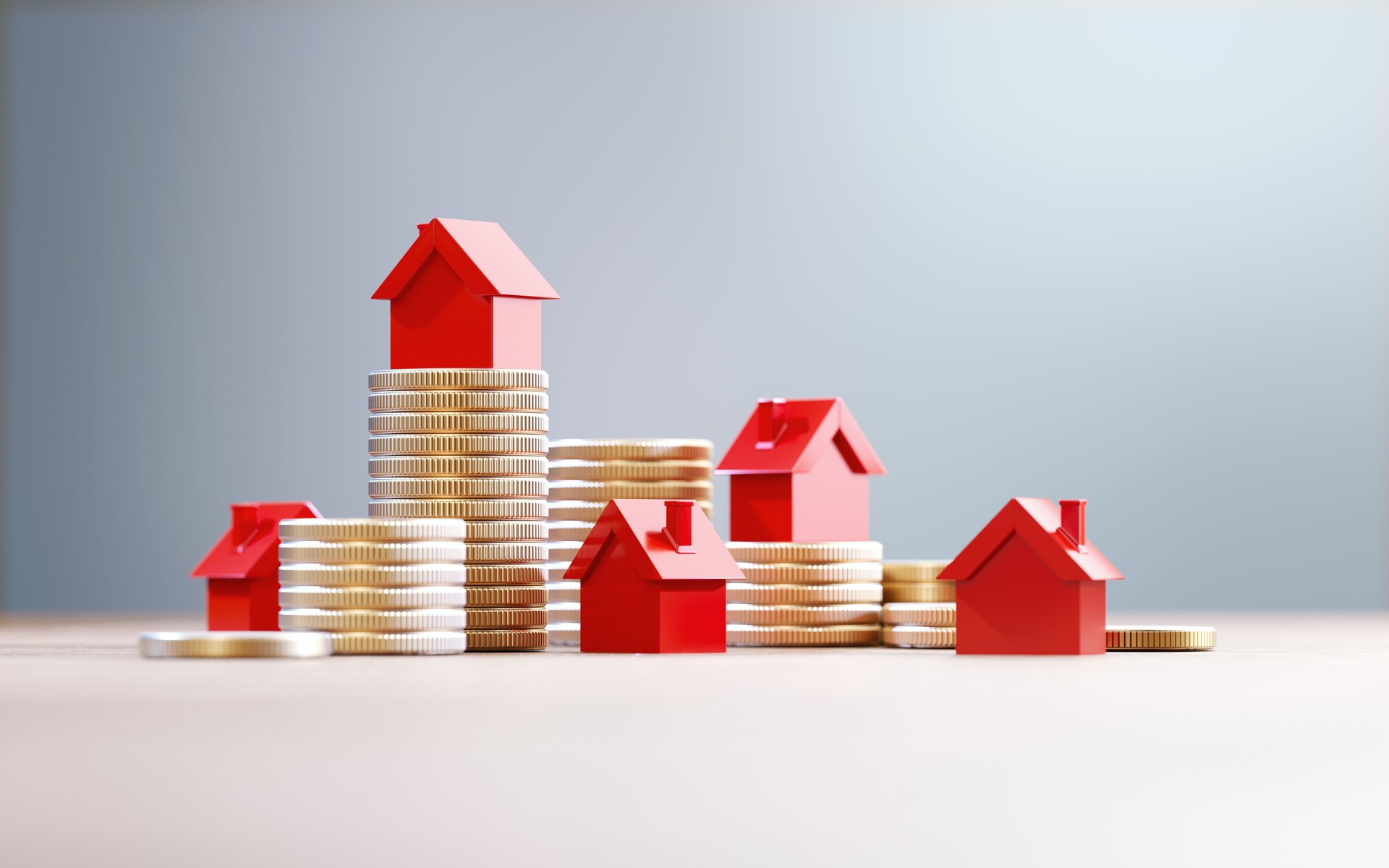 Red House Objects Over Coin Stacks Before Defocused Background - Real Estate And House Rental Concept